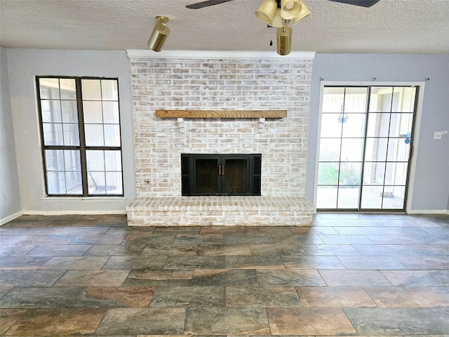 unfurnished living room featuring a brick fireplace, a textured ceiling, and ceiling fan