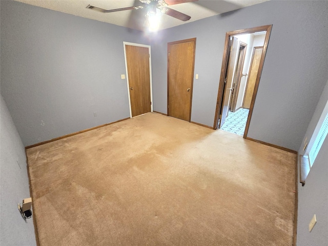 unfurnished bedroom featuring connected bathroom, light colored carpet, and ceiling fan