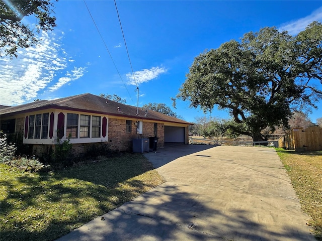 view of property exterior featuring cooling unit, a garage, and a yard