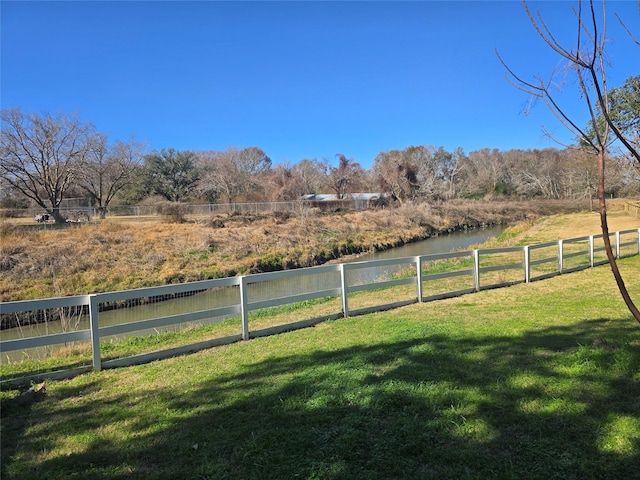 view of yard with a water view and a rural view