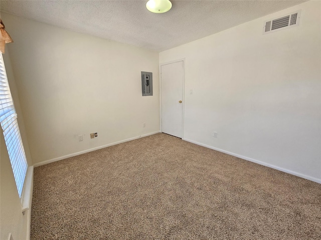 unfurnished room with a textured ceiling, electric panel, and carpet floors