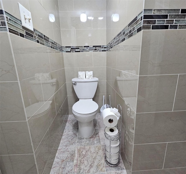 bathroom with toilet and tile walls