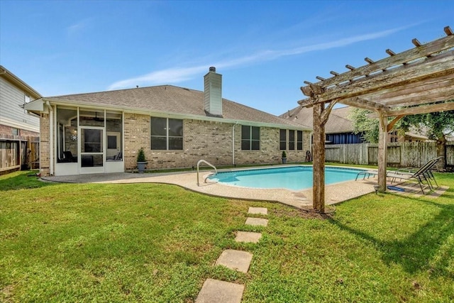 view of pool with a pergola, a sunroom, and a lawn