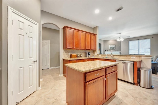 kitchen featuring dishwasher, sink, ceiling fan, a kitchen island, and kitchen peninsula