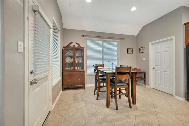 tiled dining area featuring vaulted ceiling