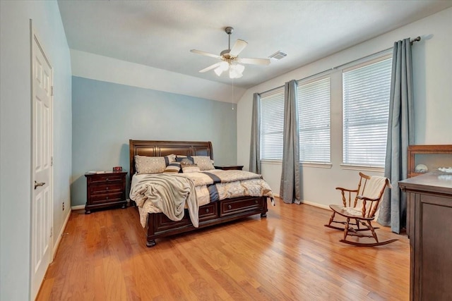 bedroom featuring light wood-type flooring, vaulted ceiling, and ceiling fan