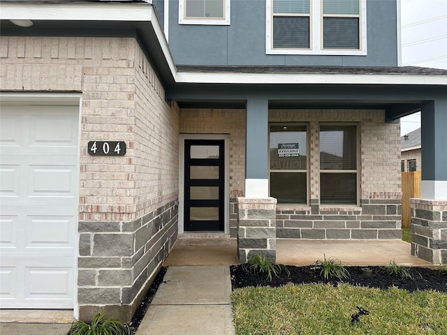 entrance to property featuring covered porch and a garage