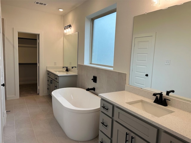 bathroom with tile patterned flooring, vanity, and a tub