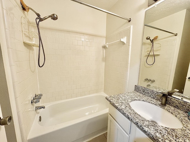 bathroom with tiled shower / bath combo and vanity