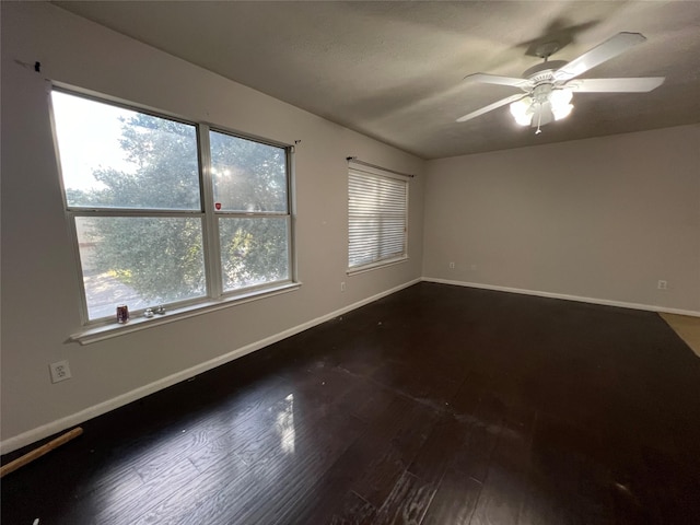 spare room featuring dark hardwood / wood-style flooring and ceiling fan