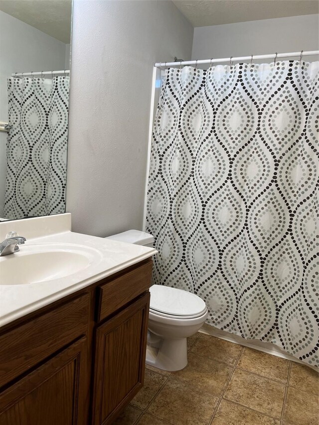 bathroom featuring a shower with curtain, vanity, and toilet