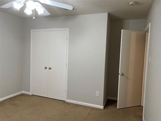 unfurnished bedroom with ceiling fan, a closet, and light carpet