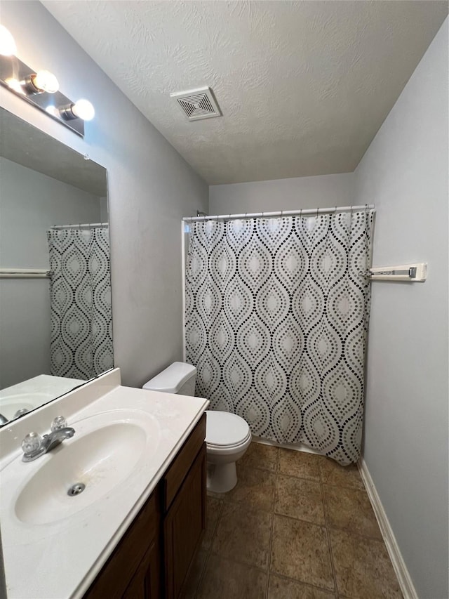 bathroom featuring vanity, toilet, a textured ceiling, and walk in shower