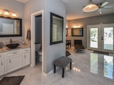 bathroom with french doors, vanity, and toilet