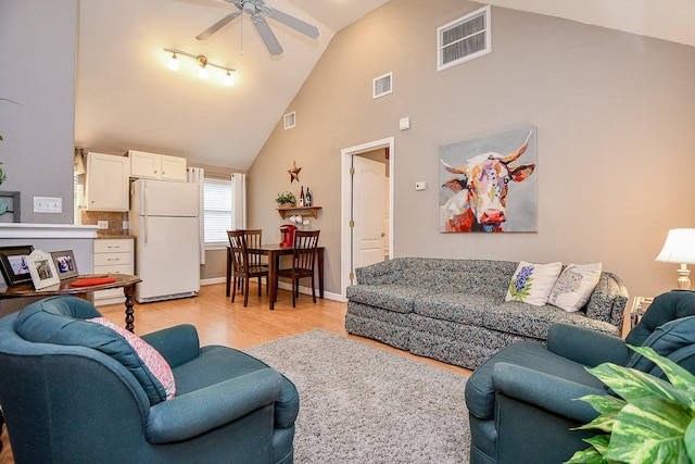 living room featuring ceiling fan, high vaulted ceiling, and light hardwood / wood-style floors