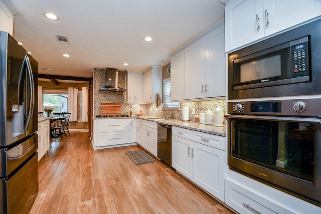 kitchen featuring white cabinets, oven, fridge with ice dispenser, and wall chimney exhaust hood