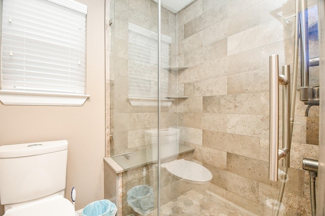 bathroom with a shower with door and toilet