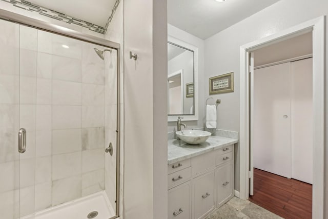 bathroom featuring hardwood / wood-style flooring, vanity, and walk in shower