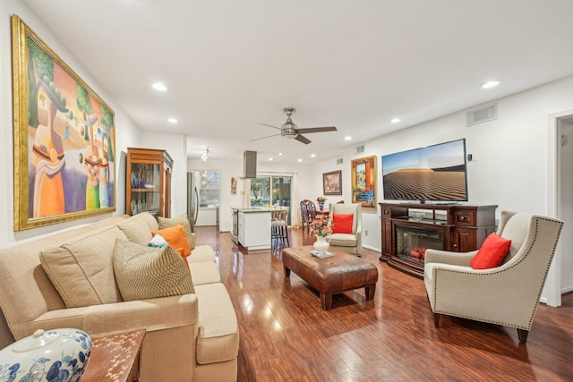 living room with ceiling fan and dark hardwood / wood-style floors