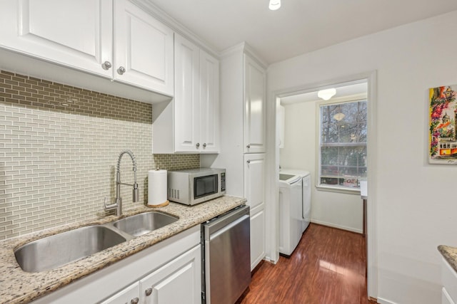 kitchen with washer and clothes dryer, decorative backsplash, dishwasher, and white cabinets