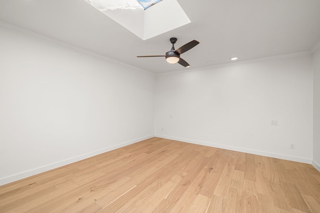 unfurnished room featuring ceiling fan, a skylight, ornamental molding, and light hardwood / wood-style flooring