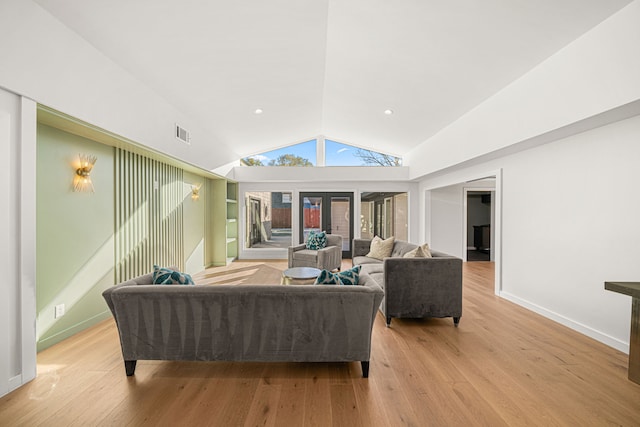 living room featuring light hardwood / wood-style flooring, lofted ceiling, and french doors