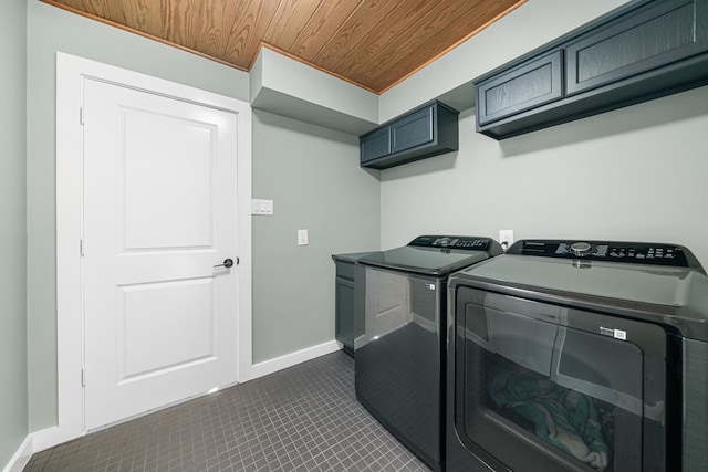 washroom featuring wood ceiling, washing machine and clothes dryer, and cabinets