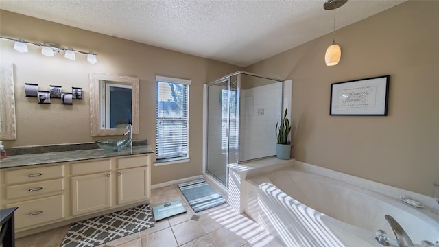 bathroom with tile patterned flooring, vanity, a textured ceiling, and shower with separate bathtub