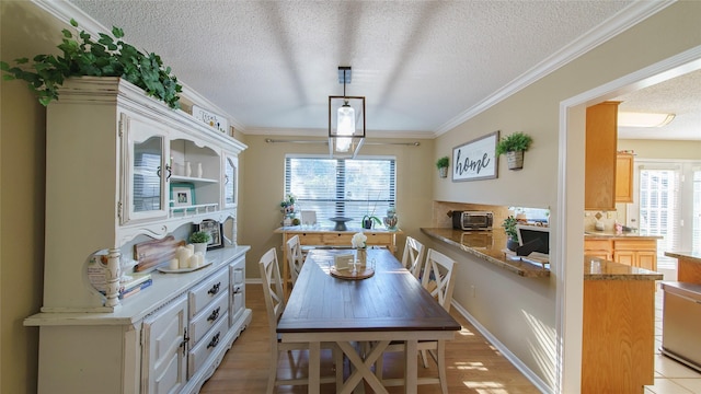 dining room with a textured ceiling and ornamental molding