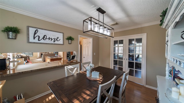 dining area featuring french doors, dark hardwood / wood-style flooring, a chandelier, a textured ceiling, and ornamental molding