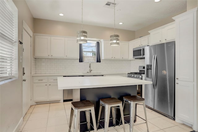 kitchen featuring a center island, white cabinetry, stainless steel appliances, and tasteful backsplash