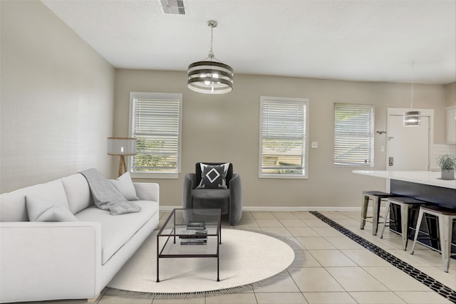 tiled living room with a chandelier