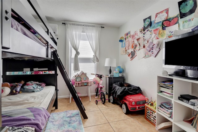 bedroom featuring light tile patterned floors and a textured ceiling