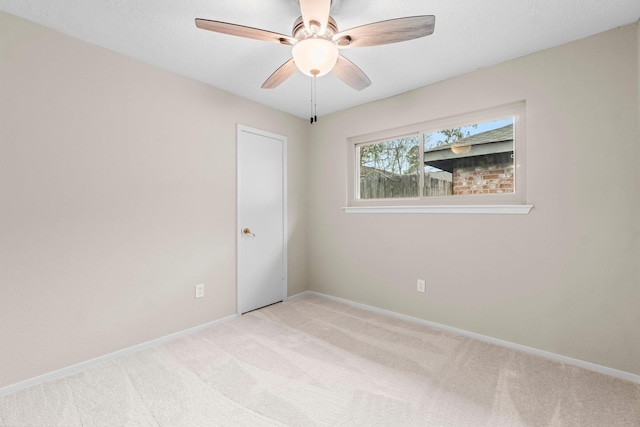 empty room featuring light colored carpet and ceiling fan