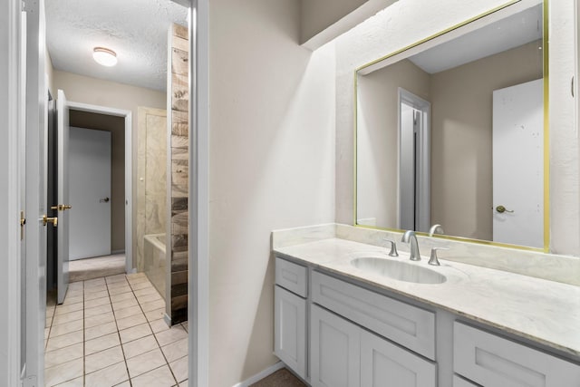 bathroom with tile patterned floors, vanity, a textured ceiling, and walk in shower