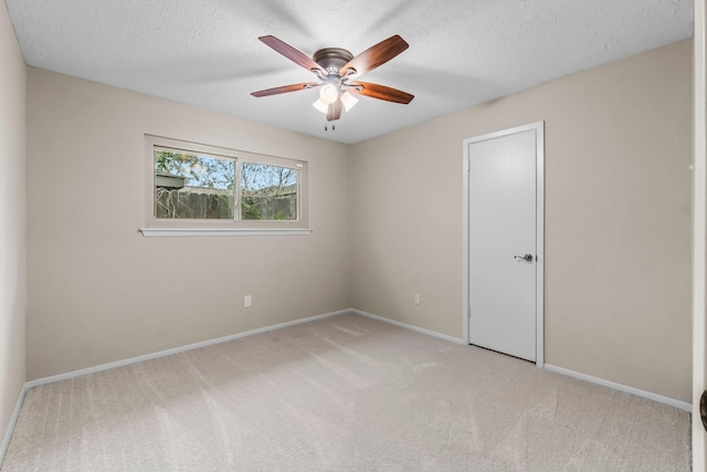 carpeted spare room with ceiling fan and a textured ceiling