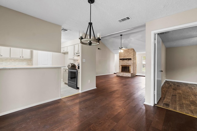 kitchen with backsplash, hardwood / wood-style flooring, white cabinetry, and stainless steel range with electric stovetop