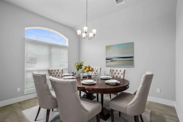 dining room with hardwood / wood-style floors and a notable chandelier