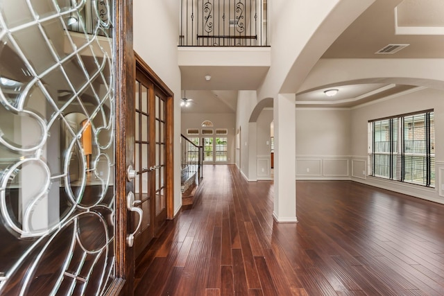 foyer with ornamental molding and dark hardwood / wood-style flooring