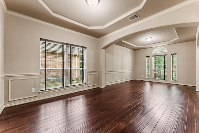 spare room featuring ornamental molding, wood-type flooring, and a raised ceiling