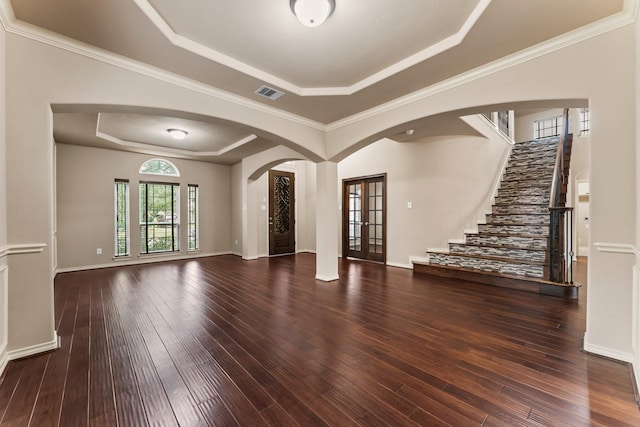 unfurnished living room featuring crown molding, dark hardwood / wood-style floors, and a raised ceiling