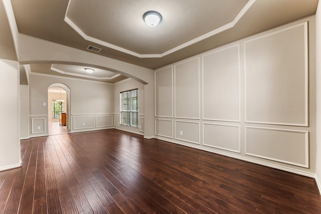 spare room with ornamental molding, a tray ceiling, and hardwood / wood-style floors