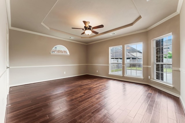 unfurnished room featuring crown molding, a tray ceiling, dark wood-type flooring, and ceiling fan