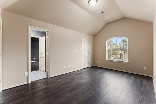 spare room with dark hardwood / wood-style floors and vaulted ceiling