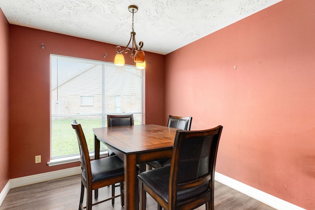 dining room with an inviting chandelier, hardwood / wood-style floors, and a textured ceiling