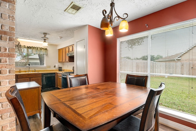 dining area with sink, a chandelier, and a textured ceiling