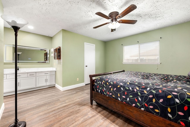 bedroom featuring ceiling fan, light hardwood / wood-style flooring, and a textured ceiling