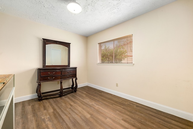 bedroom featuring hardwood / wood-style flooring and a textured ceiling