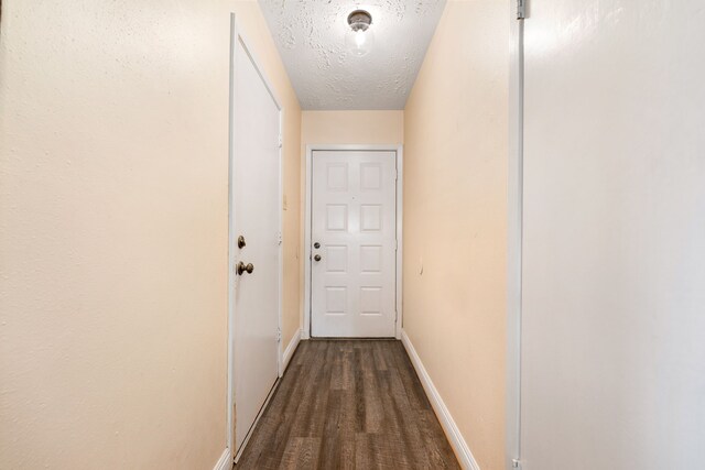 hall with wood-type flooring and a textured ceiling