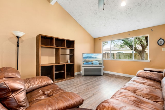 living room featuring lofted ceiling, hardwood / wood-style floors, and a textured ceiling